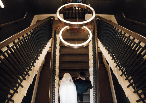 View from above of bride and groom walking up stairs